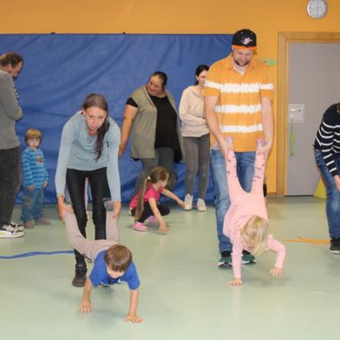 Eltern machen mit ihren Kindern Schubkarrenrennen